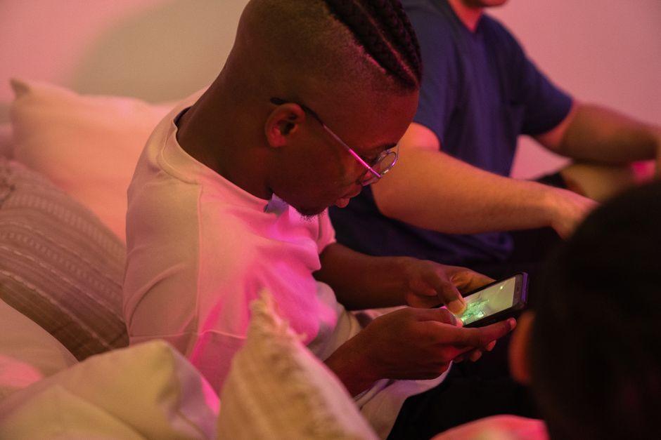 Group of friends enjoying a casual evening playing games on mobile phones indoors.
