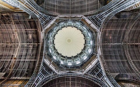 Intricate dome ceiling showcasing modern architecture with a symmetrical design from a low angle view.