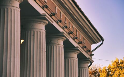 Beautiful neoclassical columns of a building captured during the day.