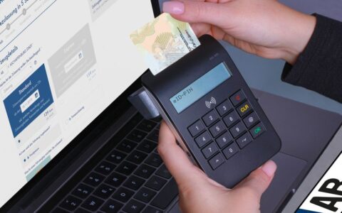 Close-up of a contactless payment using a card reader and laptop, highlighting digital security.